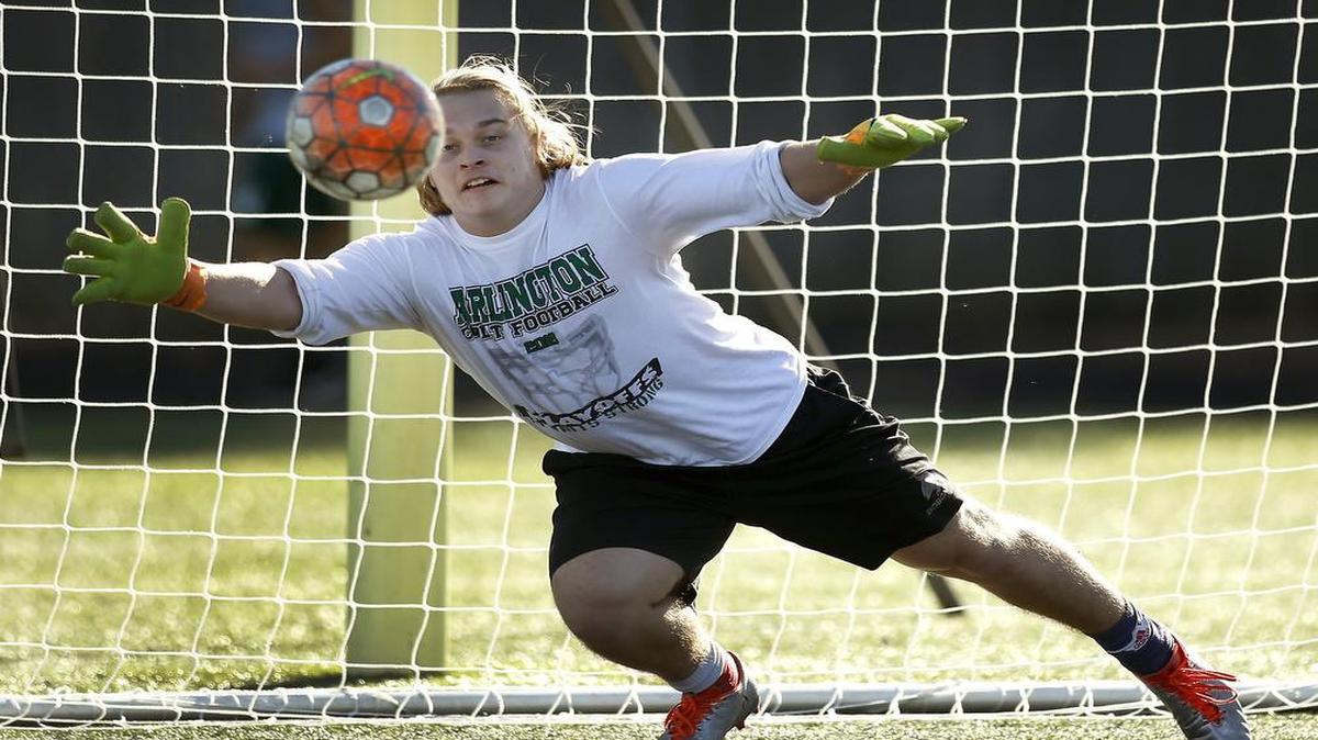 Arlington High boys soccer goalie Ben Carroll deflects a shot during practice, Jan. 23, 2016.