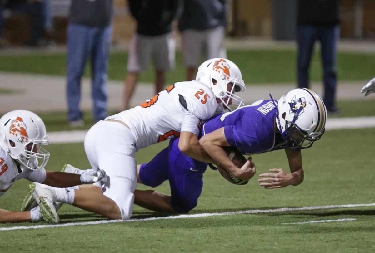 Aledo linebacker Wyatt Harris tackles Denton quarterback Colt Atkinson for a loss at the 1-yard line in Friday's 5A Division I area playoff game at Northwest ISD Stadium.