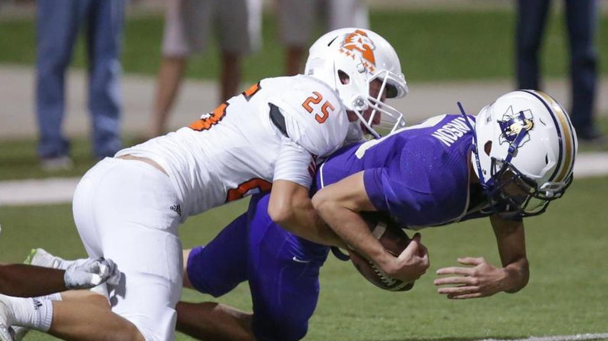 Aledo linebacker Wyatt Harris tackles Denton quarterback Colt Atkinson for a loss at the 1-yard line in Friday's 5A Division I area playoff game at Northwest ISD Stadium.