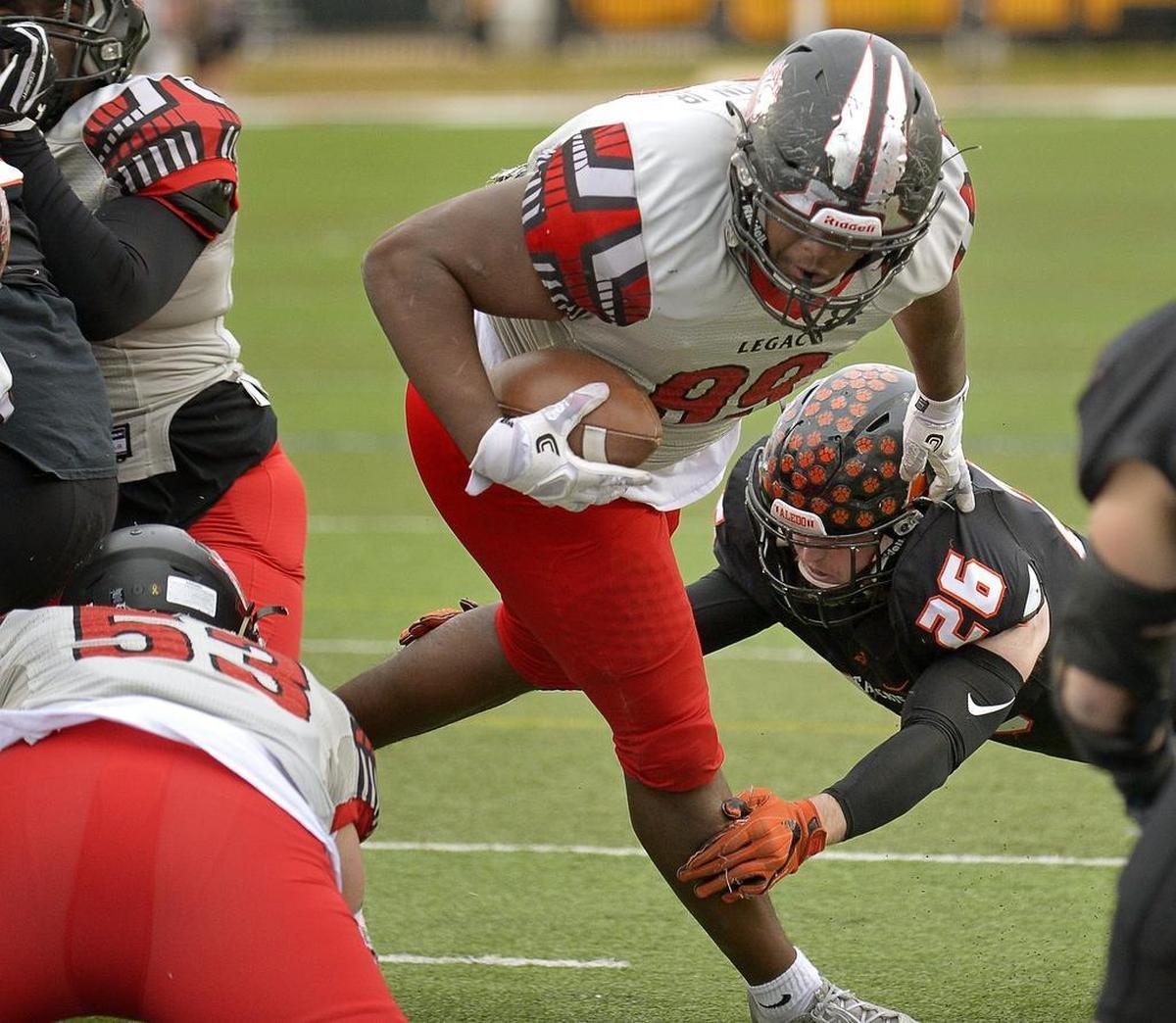 Legacy’s Enoch Jackson (99) scores from a yard out despite the defensive effort of Aledo’s Aaron Hale (26).