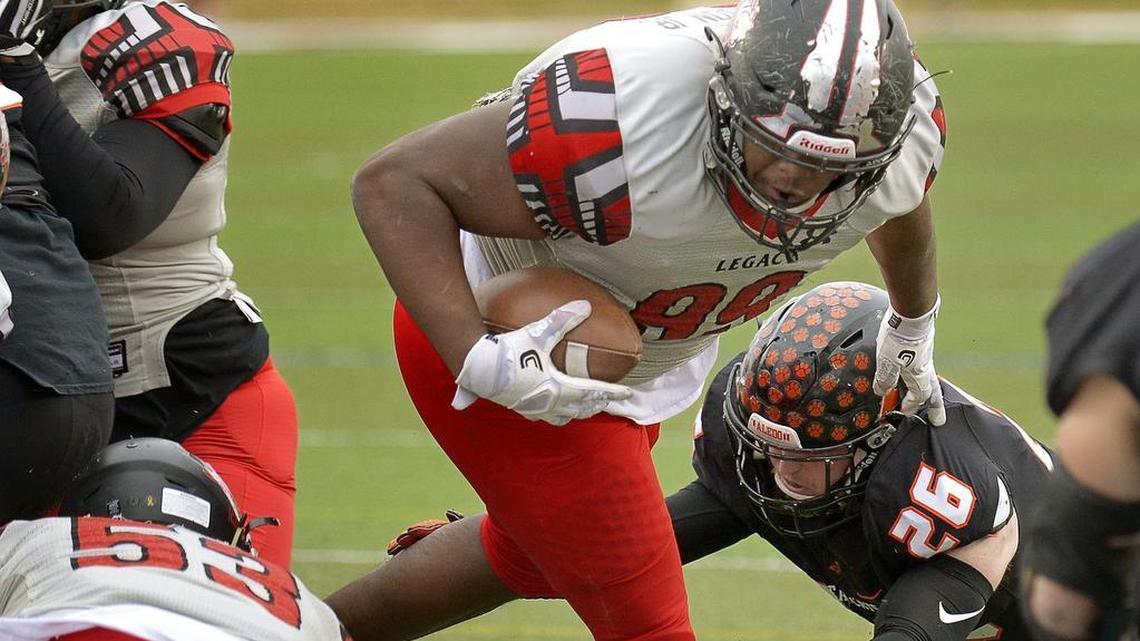 Legacy’s Enoch Jackson (99) scores from a yard out despite the defensive effort of Aledo’s Aaron Hale (26).