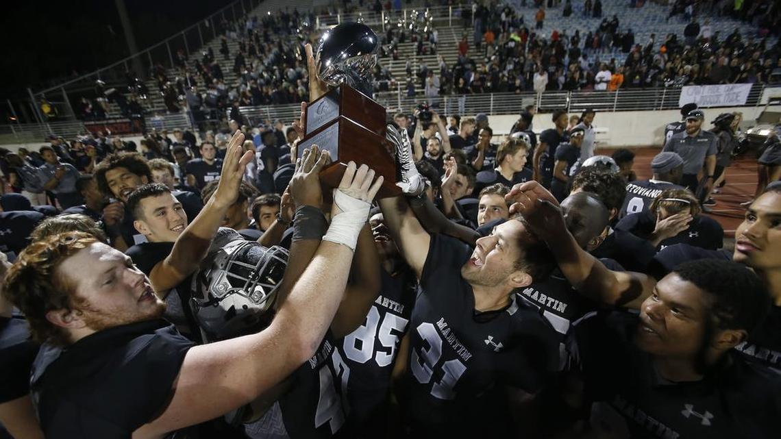 Arlington Martin players hoist their area championship trophy after a 41-10 win against the Odessa Permian Panthers at UTA’s Maverick Stadium in Arlington.