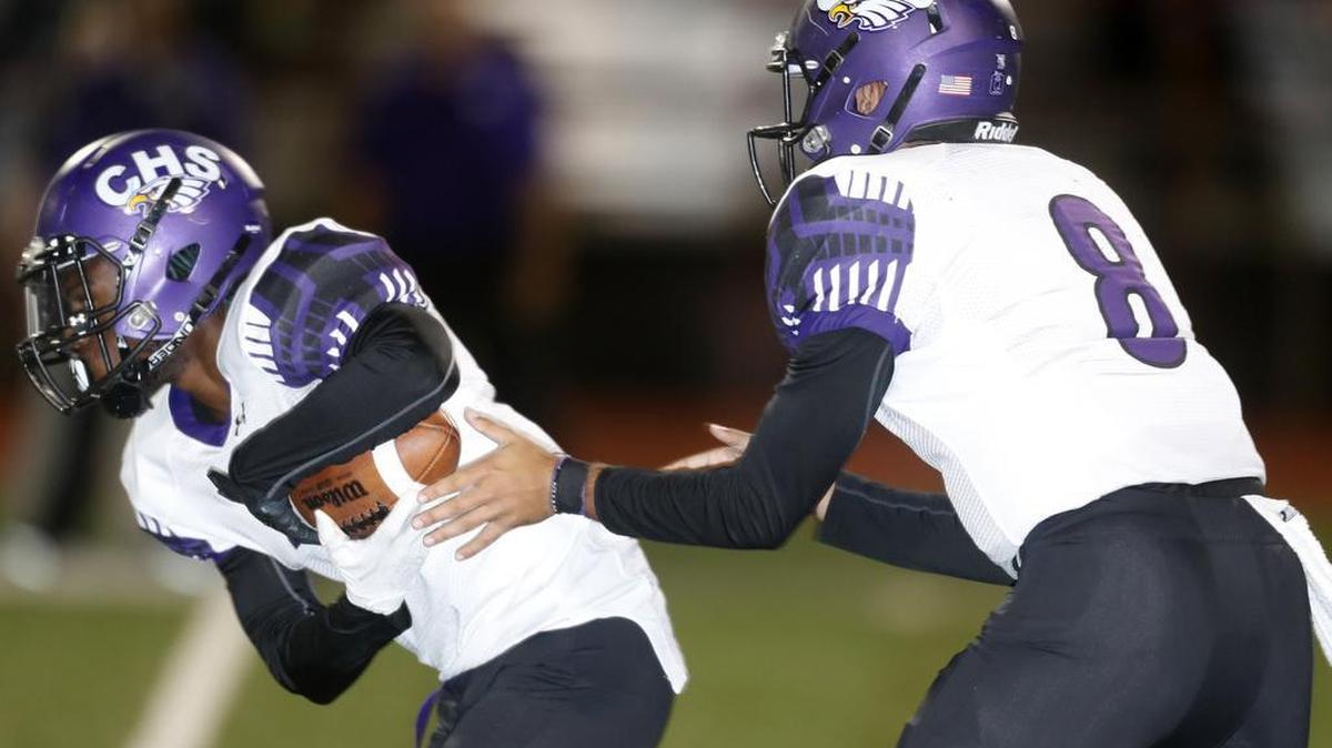 Crowley quarterback Chris James (8) hands the ball to Crowley running back Marvin Haley.