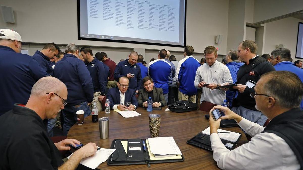 Highland Park head football coach Randy Allen (seated center-left) and athletic director Johnny Ringo (standing) work on filling their 2018-19 football schedules during a UIL realignment meeting at the Birdville ISD Fine Arts/Athletic Complex, February 1, 2018.
