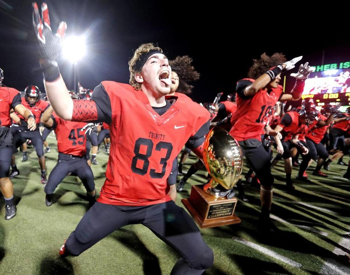 Trinity tight end Lane Polston (83) celebrates with the trophy and teammates after winning the 6A Division I Region I playoff game at Pennington Field Friday November 17, 2017. Trinity defeated Plano with the first play of overtime 28-21.