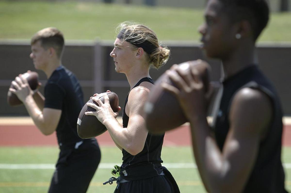 Quarterbacks Zach Earhart, Noah Wineteer and Shayne Lawrence work with instructors from Quarterback Ranch at Trinity High School. Private instruction is becoming more popular. 
