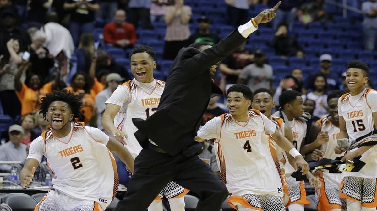 Lancaster coach Ferrin Douglas, center, and his players charge onto the court after defeating Fort Bend Elkins in a UIL Class 5A boys high school state final basketball game, Saturday, March 12, 2016, in San Antonio. Lancaster won 67-64.