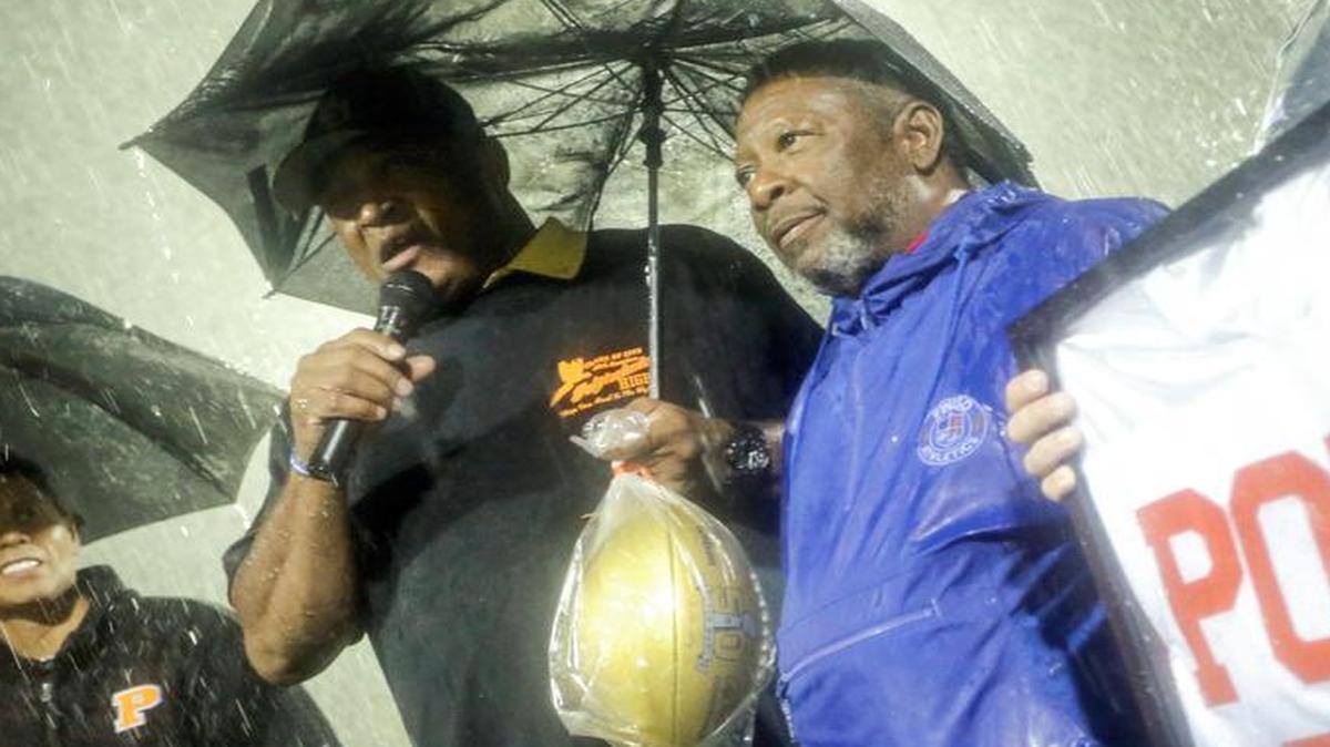 Former Polytechnic coach Arthur McCoy, in blue, joins former NFL player and Poly grad Greg Hawthorne during Thursday’s ceremony.