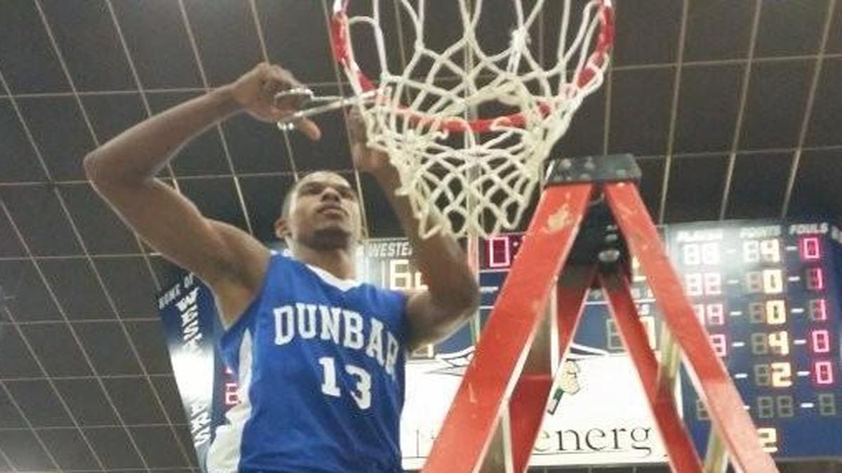 Dunbar’s Quinton Brigham cuts down the net at Western Texas College Coliseum in Snyder after the Wildcats’ 95-62 defeat of Wichita Falls Rider in the 5A Region I final Saturday.