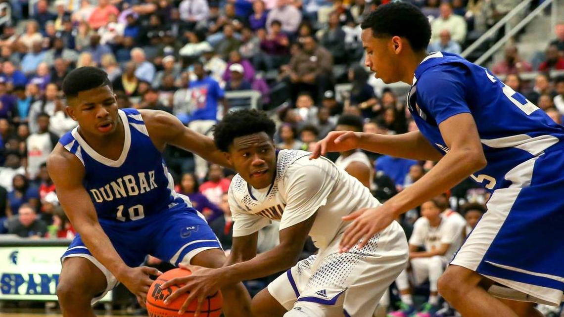 Dunbar’s Logan Ray, left, and Jarrod Fields, right, apply pressure to Everman forward Jonathan Jackson.