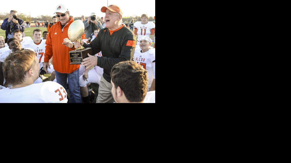 
Aledo High School head coach Steve Wood accepts the 5A Division I semifinal high school football championship trophy from Aledo athletic director Tim Buchanan after the Bearcats defeated Tyler High School 44-14 at Hanby Stadium in Mesquite, Texas, Saturday, December 13, 2014. 
