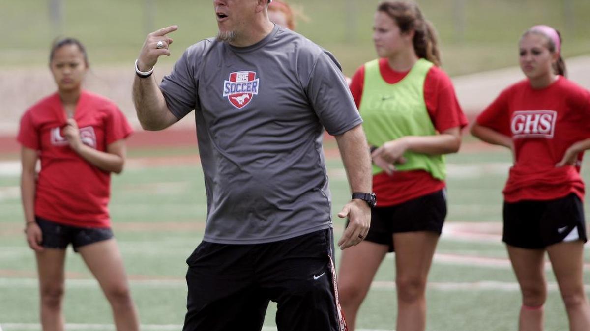 Grapevine coach Steven McBride instructs the team during practice Tuesday afternoon. McBride told the team, “You need to give it your all, go all out. Seniors will never play on this field again as Mustangs.”