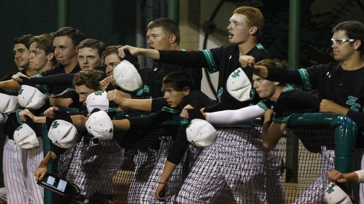 Players in the Carroll dugout use their caps to try to distract Richland pitcher Ricky Perez.