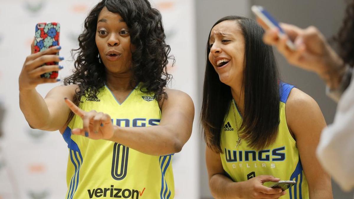 Dallas Wings players Odyssey Sims, left, and Brianna Kiesel smile as they joke around with Sims’ smart phone during the WNBA basketball team’s media day on May 5. The Wings play their inaugural home game at College Park Center on the UT Arlington campus at 7:30 p.m. Saturday. TV coverage is on FSSW and NBA TV.
