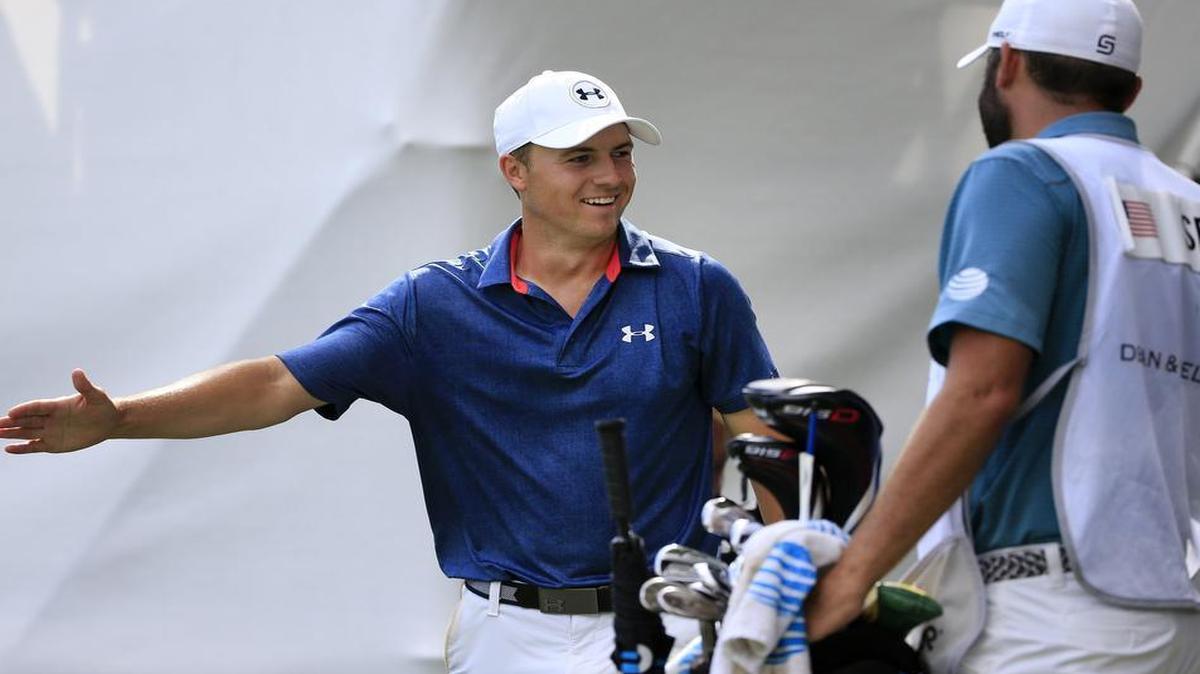 Jordan Spieth celebrates with caddie Michael Greller after making a birdie from off the green on the 17th hole during Sunday’s final round of the Dean & DeLuca Invitational.
