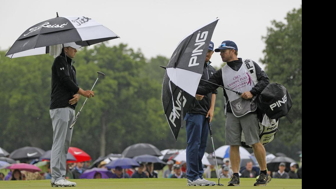 
Jordan Spieth and Hunter Mahan stay under umbrellas as long as possible on the sixth green on the second day of the Crowne Plaza Invitational at Colonial. There is a 70 percent chance of showers and thunderstorms on Saturday and a 90 percent chance of the same on Sunday.
