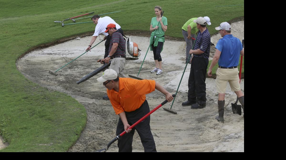 
Volunteer workers repair a sand trap before the start of the second round of the AT&T Byron Nelson Championship Friday morning. Heavy overnight rains delayed the start of play.

