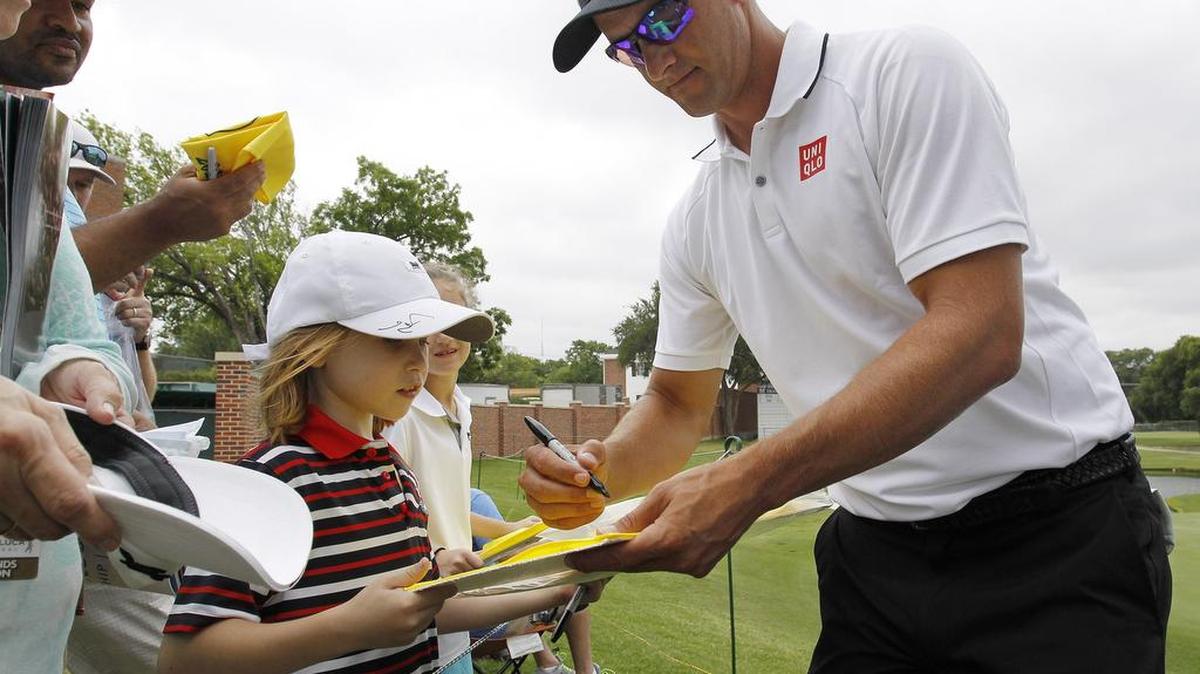 2014 tournament winner Adam Scott signs a flag for Alex Wimmiams (age 7, McKinney) during Colonial Pro-Am at the Dean & Deluca Invitational Wednesday, May 25, 2016, in Fort Worth.