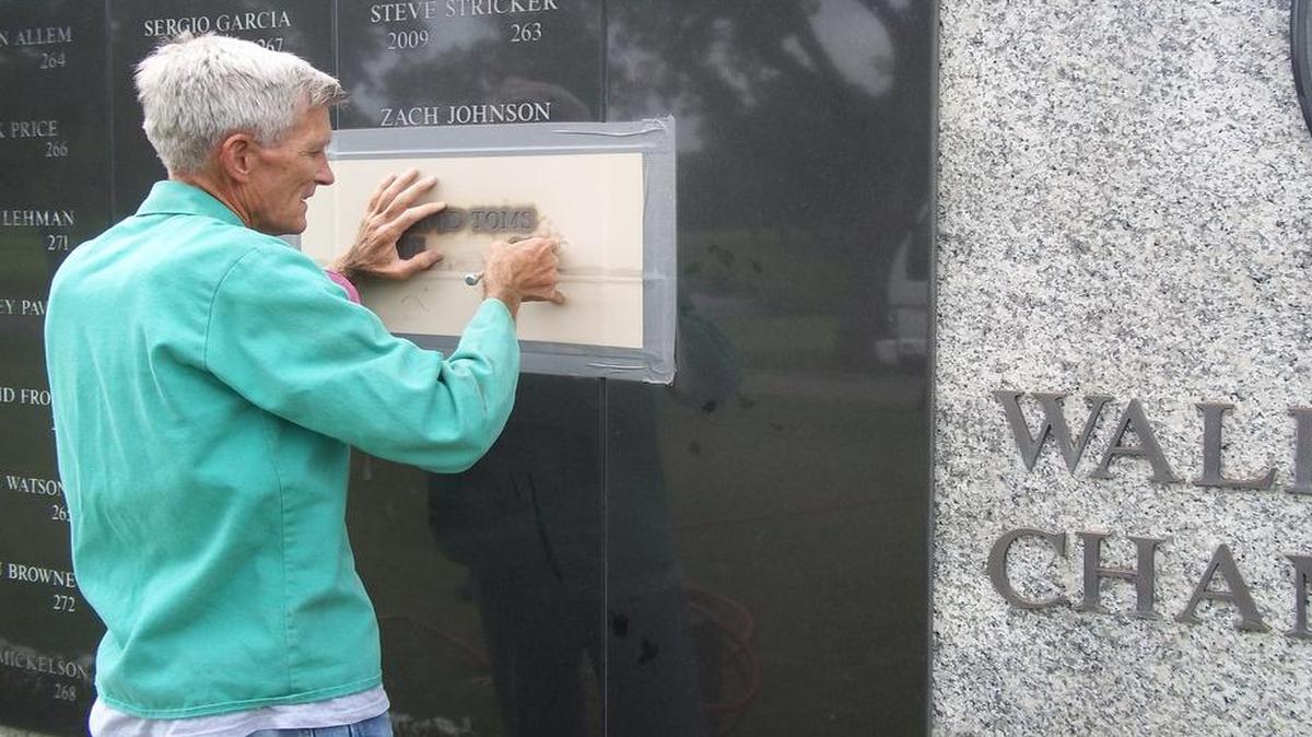 Dennis Peters inscribes the name of David Toms, the 2011 champion, into the Wall of Champions at Colonial.