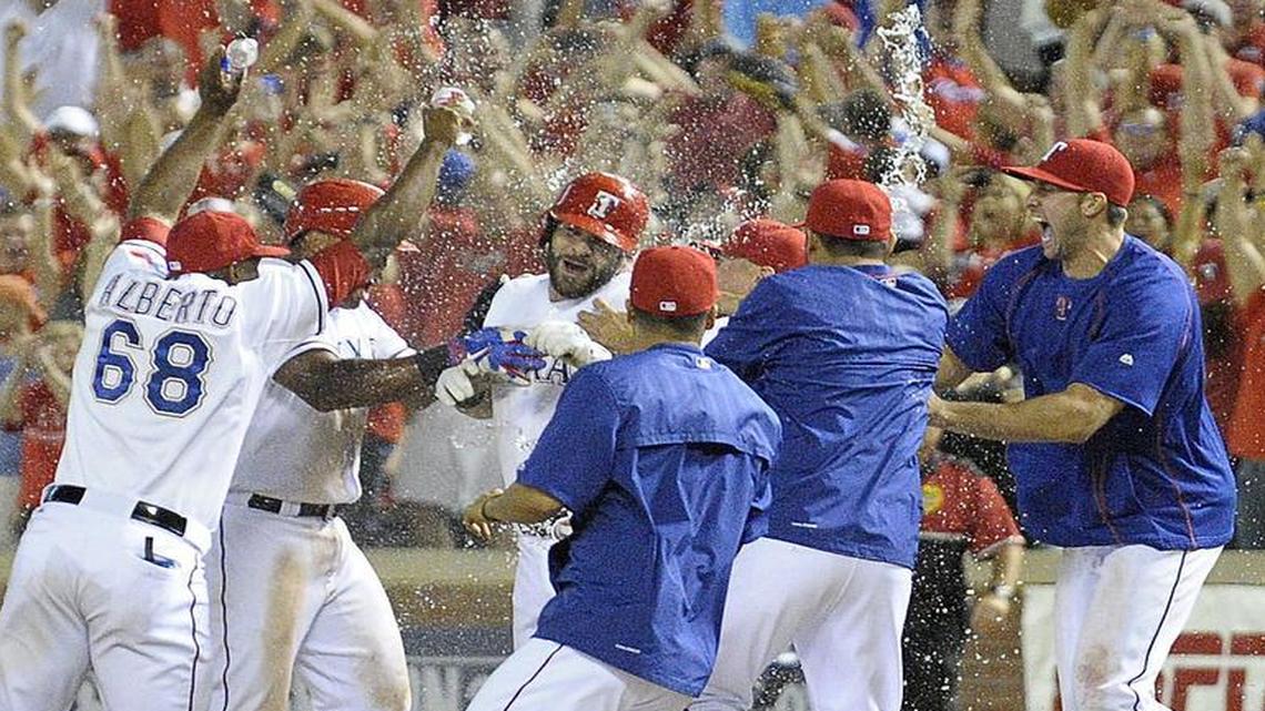 
Texas Rangers mob first baseman Mitch Moreland (18) after he hit a sacrifice fly ball to win the game in the ninth inning as the Texas Rangers beat the Houston Astros 6 to 5 at Globe Life Park in Arlington, TX, Tuesday, Sept. 15, 2015. 
