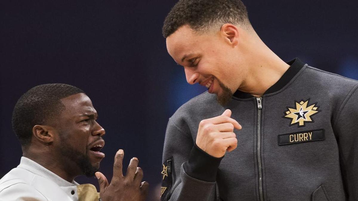 Actor Kevin Hart talks with Golden State Warriors guard Stephen Curry (30) before the first half of the NBA All-Star basketball game on Sunday.