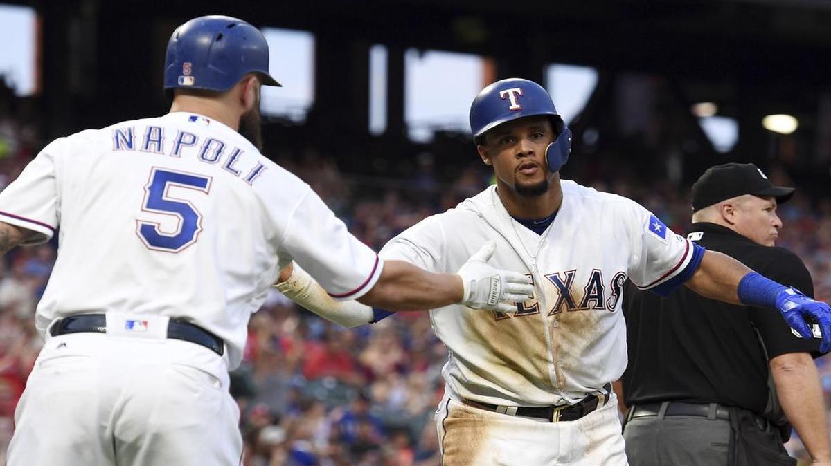 Rangers center fielder Carlos Gomez is congratulated by Mike Napoli after scoring on a single by Joey Gallo in the fourth inning Saturday.