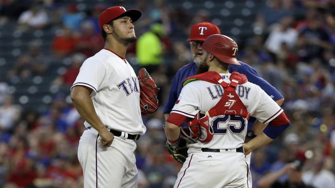 Yu Darvish, left, catcher Jonathan Lucroy and pitching coach Doug Brocail, right, talk on the mound during the Marlins’ nine-run fourth inning Wednesday night.