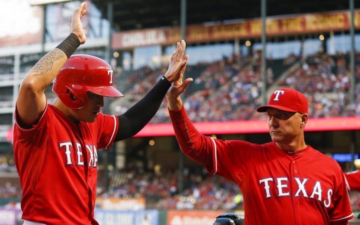 
Rangers’ outfielder Shin-Soo Choo celebrates his score against the Mariners with manager Jeff Banister, right, during the first inning Saturday of the Rangers’ 10-1 win at Globe Life Park. Choo is 12 for 16 in his past four games.
