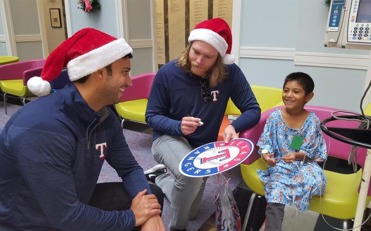 Rangers pitcher A.J. Griffin, middle, and Matt Bush, left, visit with a patient at Cook Children’s in Fort Worth on Wednesday.