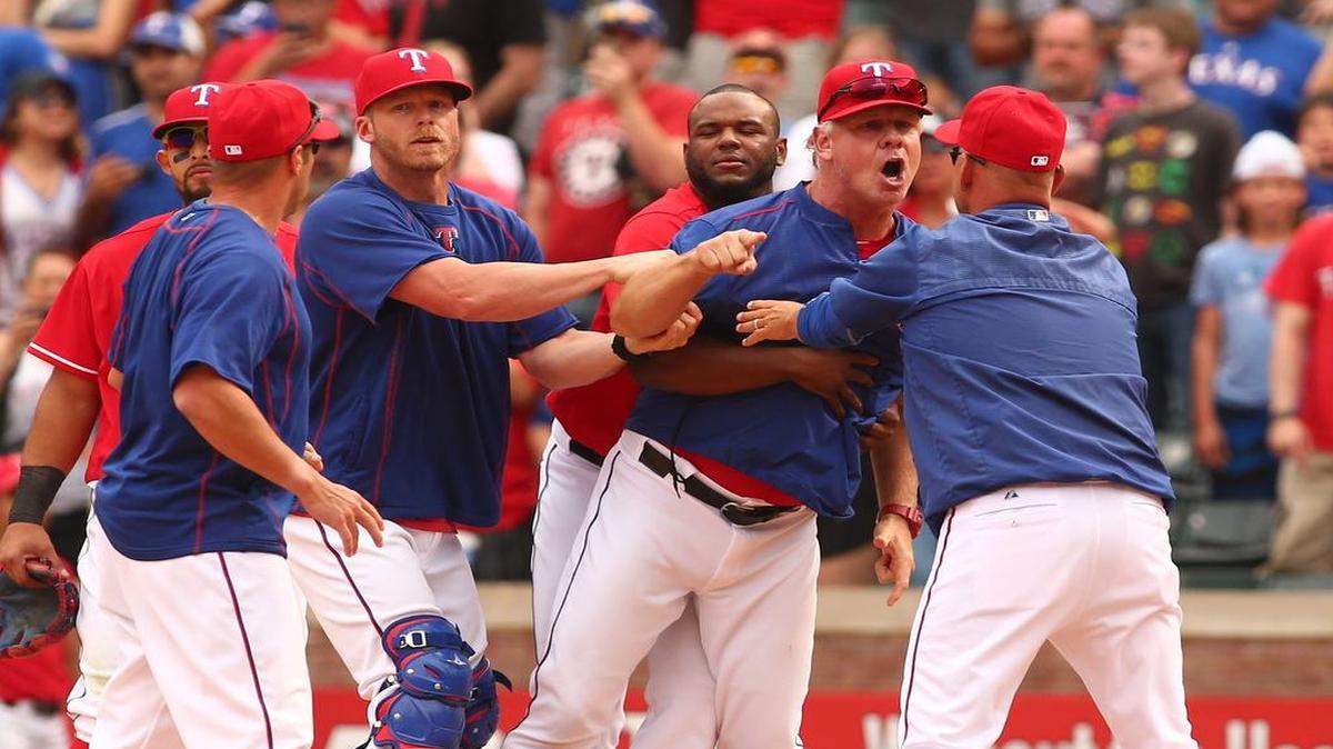 Rangers bench coach Steve Buechele is held back by players and coaches after a bench-clearing fight erupted between Texas and Toronto on May 15 at Globe Life Park.