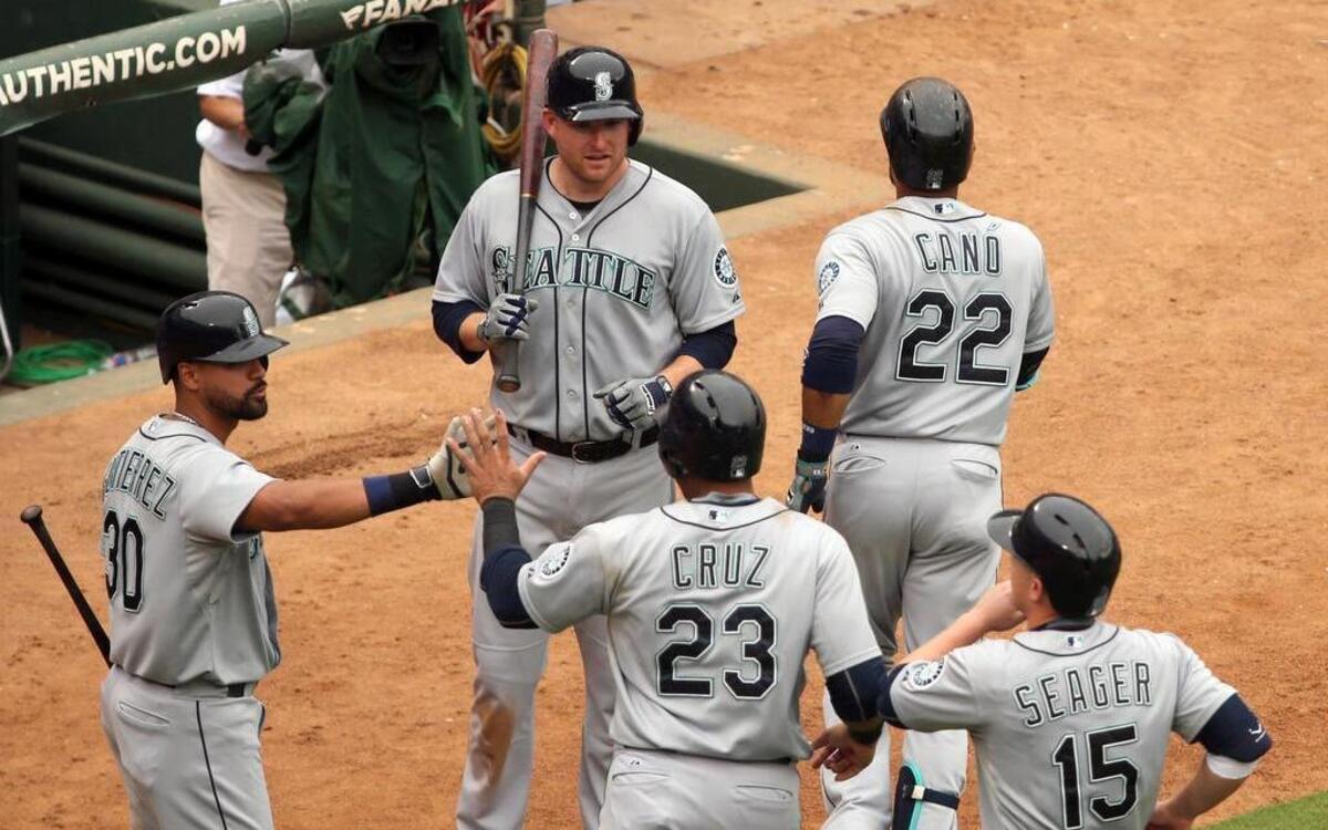 
Mariners Franklin Gutierrez (30) and Mark Trumbo (35) congratulate Nelson Cruz (23), Kyle Seager (15) and Robinson Cano (22) after Cano’s three-run homer against Derek Holland in the fifth inning Sunday at Globe Life Park. Seattle won 9-2.
