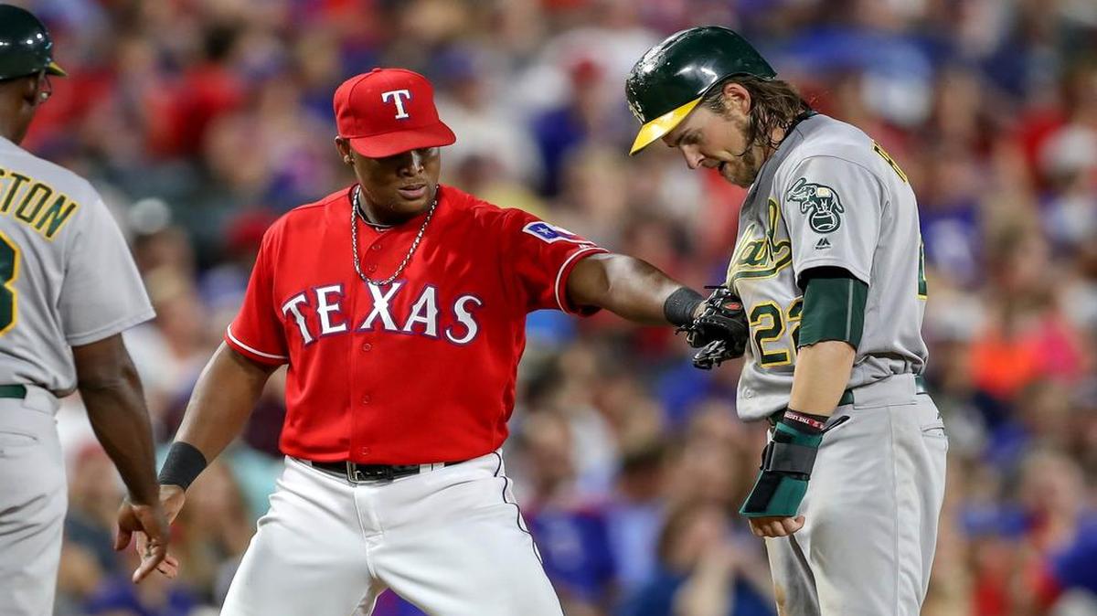 Adrian Beltre, left, tries to tag Josh Reddick during the sixth inning Wednesday night at Globe Life Park. Oakland beat Texas 6-3.