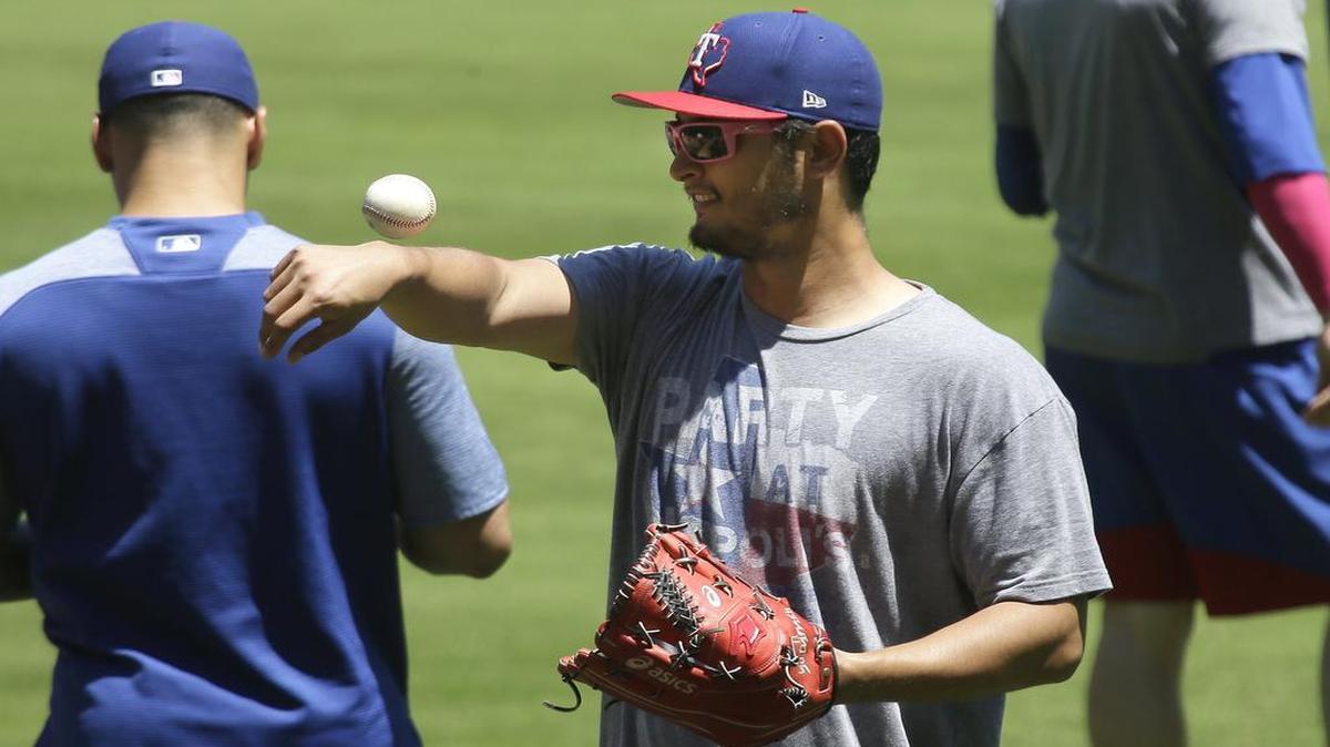 Yu Darvish tosses a ball around in the outfield during batting practice before Sunday’s game against the A’s. Darvish starts the series opener Tuesday against the Phillies.