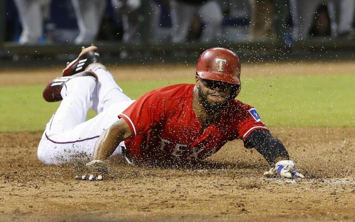 
Rangers outfielder Delino DeShields dives home to score on a double by Adrian Beltre on Saturday. DeShields did not start Sunday to rest and allow a sore left knee to recover.
