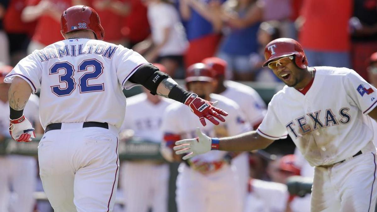 
Rangers outfielder Josh Hamilton is congratulated by teammate Elvis Andrus, right, after Hamilton’s solo home run in the seventh inning Saturday afternoon. It was Hamilton’s second homer of the game. Texas lost 11-10 at the Los Angeles Angels rallied to score five in the ninth.
