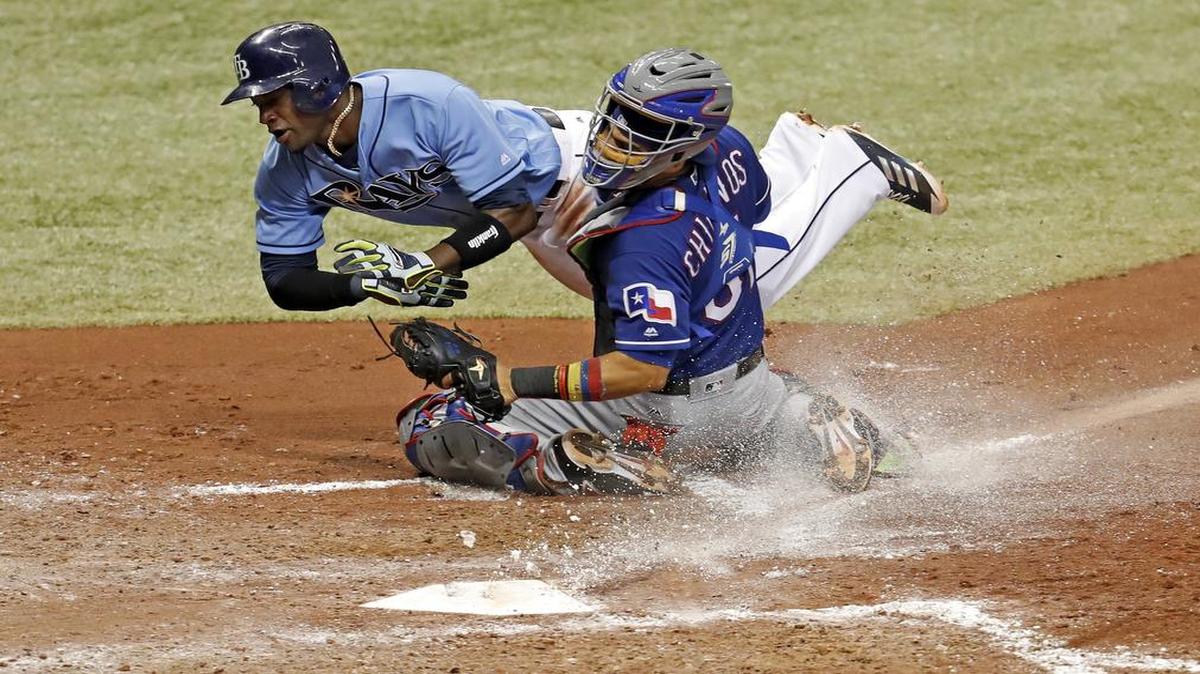 The Rays’ Adeiny Hechavarria collides with Rangers’ catcher Robinson Chirinos after being tagged out at home during the fourth inning Sunday. Chirinos had to leave the game in the fifth with a sprained left ankle. An MRI scan was negative but the severity of the sprain is not yet known.