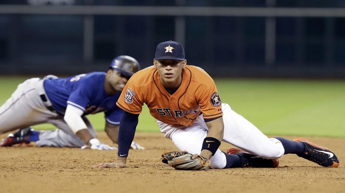 
Astros shortstop Carlos Correa, right, and Rangers’ Delino DeShields watch as Rougned Odor is safe at first on an attempted double play in the fifth inning Friday night in Houston.
