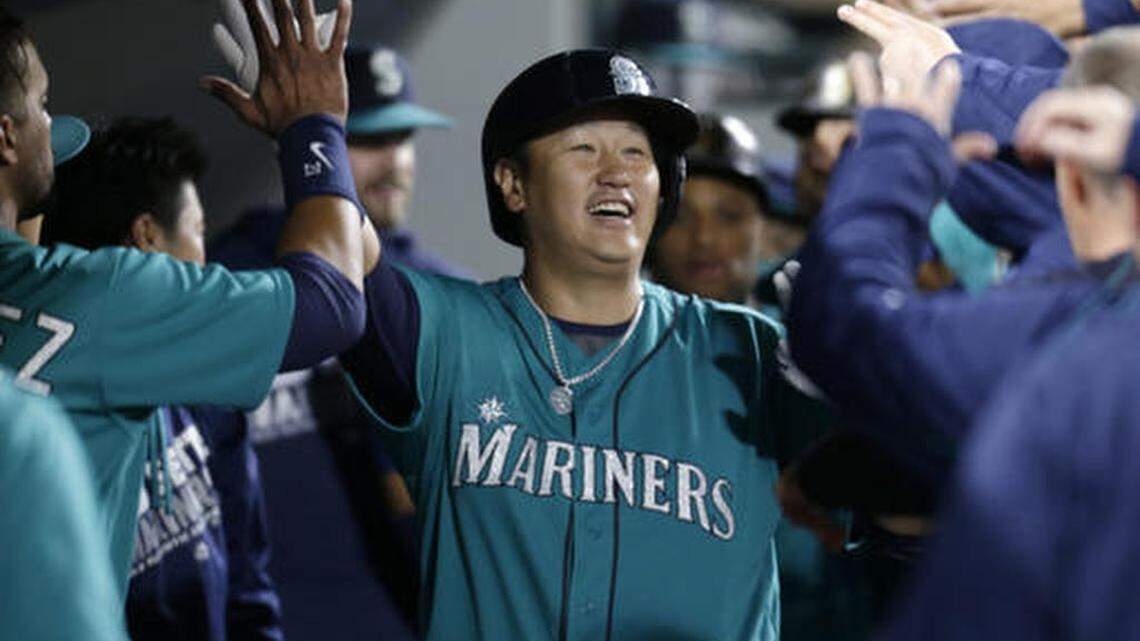 Seattle Mariners' Dae-Ho Lee celebrates in the dugout after hitting a three-run home run off Texas Rangers' Derek Holland during fourth inning of a baseball game Friday, June 10, 2016, in Seattle. This is his second home run of the night.