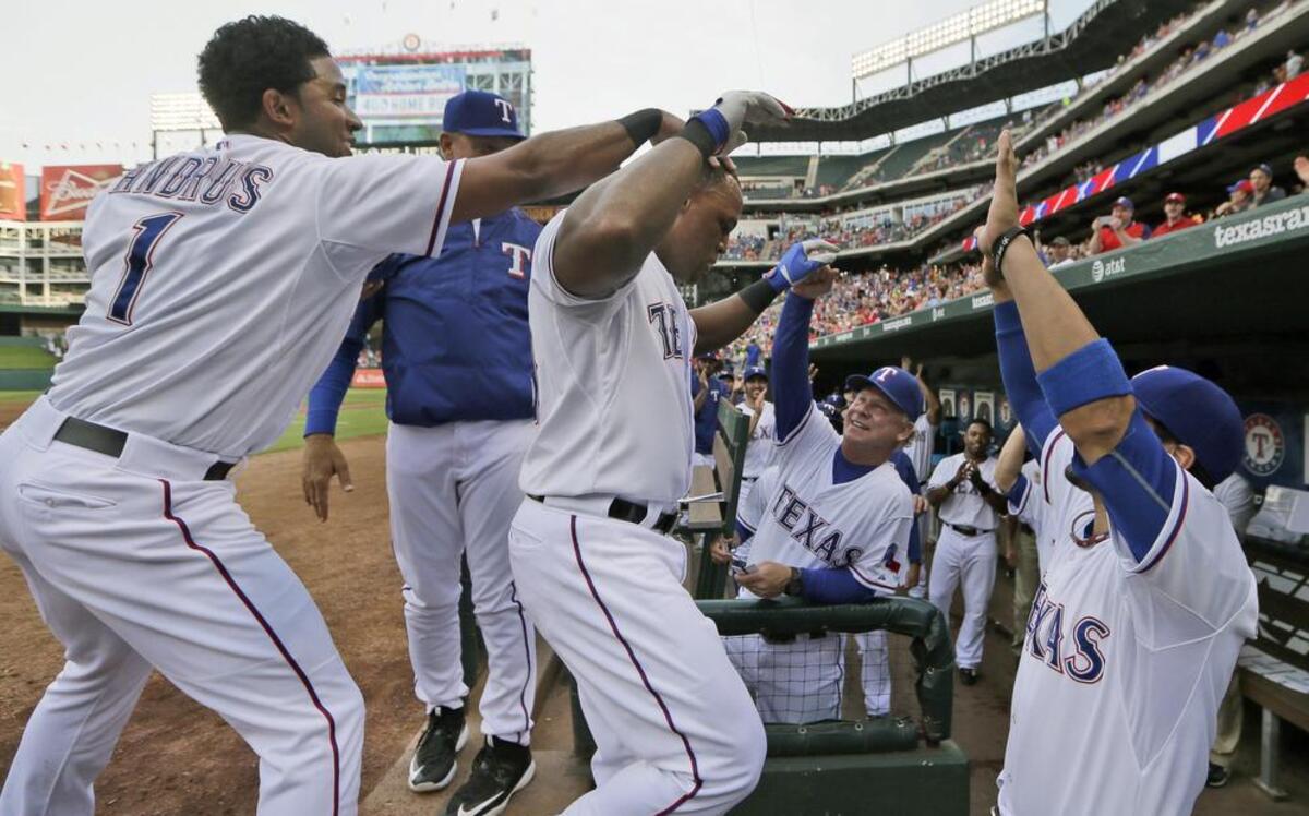 
Rangers slugger Adrian Beltre, center left, celebrates his 400th home run with Elvis Andrus (1), Robinson Chirinos, right, and bench coach Steve Buechele during the first inning Friday against the Indians.
