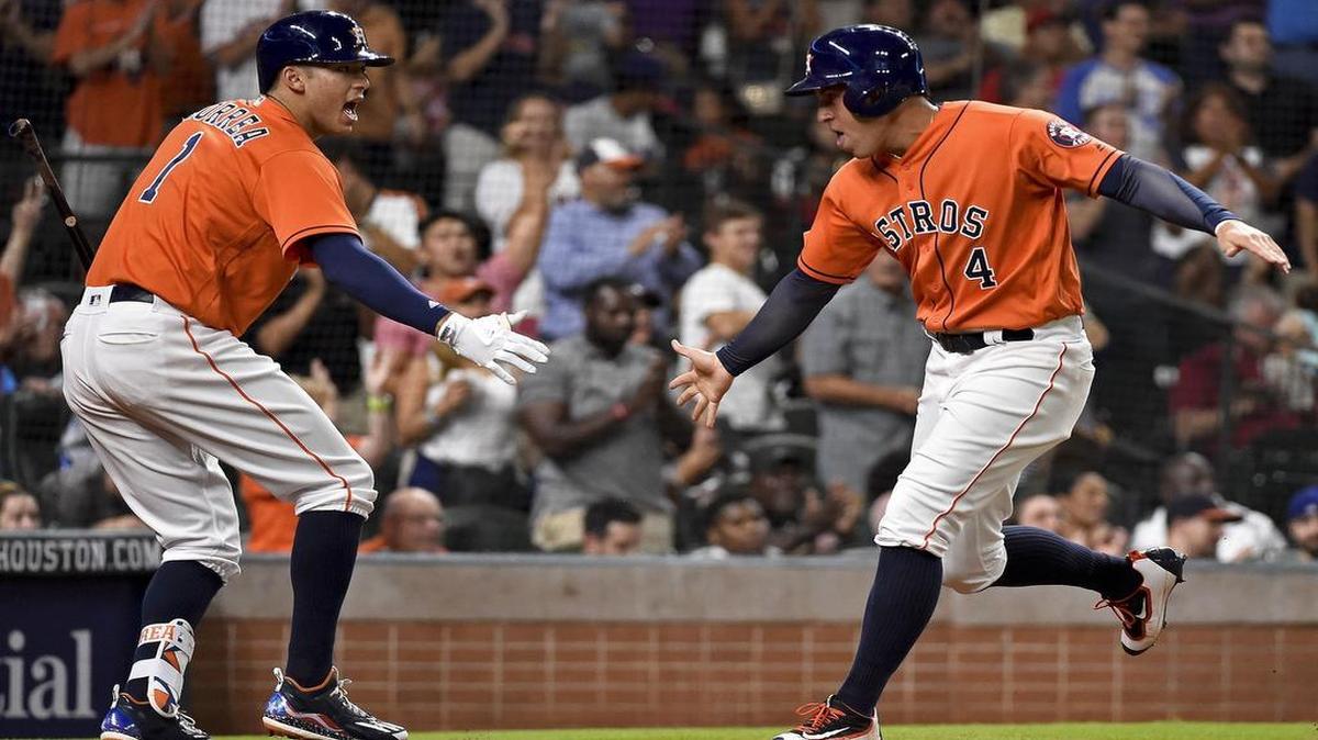 George Springer celebrates with Carlos Correa after scoring on Jose Altuve’s double in the third inning Friday night. The Astros beat the Rangers 5-0 at Minute Maid Park.