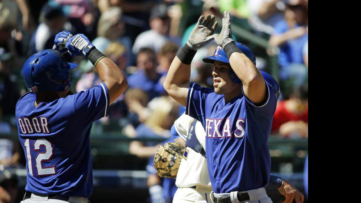 
Jake Smolinski is greeted at home plate by Rougned Odor after hitting a two-run homer in the Rangers’ seven-run third inning.
