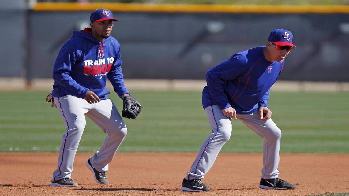 Rangers shortstop Elvis Andrus, left, and manager Jeff Banister, acting as a base runner, take part in a bunt-fielding drill for pitchers Wednesday morning in Surprise, Ariz.