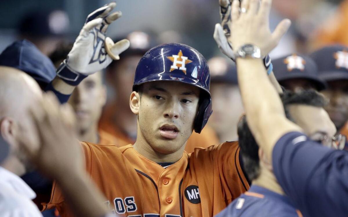 
Astros’ rookie Carlos Correa is congratulated after hitting one of two homers against the Rangers Saturday afternoon at Minute Maid Park. Correa and the Astros evened the series with an 9-4 win.

