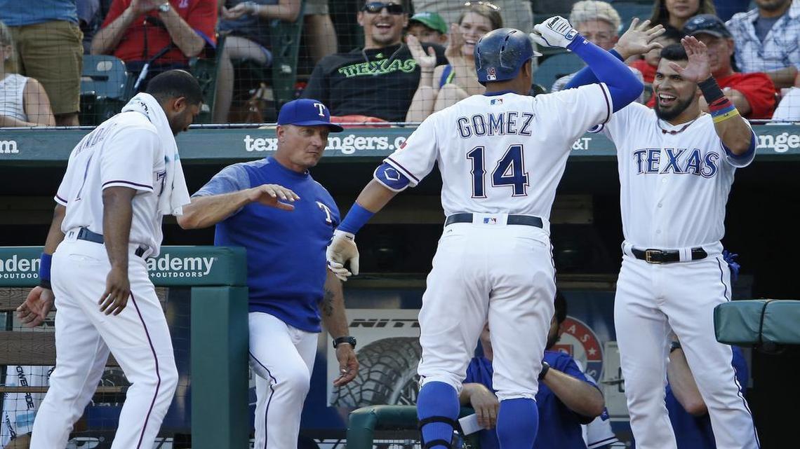 Elvis Andrus, left, manager Jeff Banister and designated hitter Robinson Chirinos, right, greet Carlos Gomez in the dugout after a home run during a game in June. The Rangers have 135 home runs, third-most in the majors at the All-Star break.