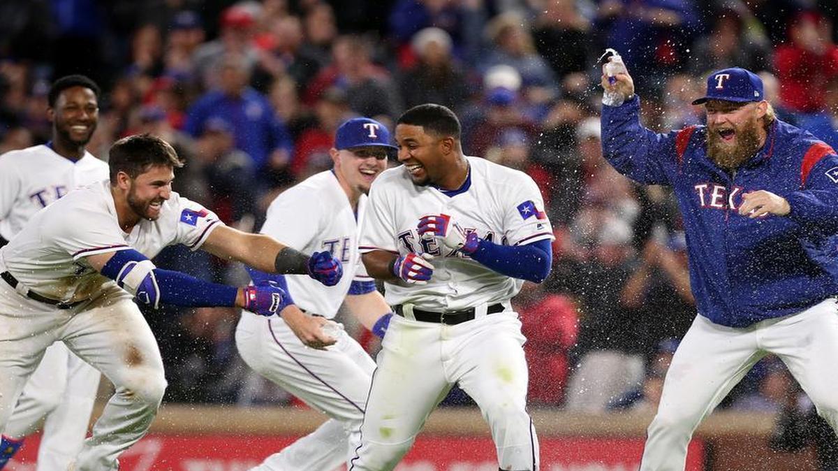 Texas Rangers Jurickson Profar (19), Joey Gallo (13), Ryan Rua (16), and Andrew Cashner (54) chase Elvis Andrus (1) on the field after Andrus doubled in Rougned Odor to beat the Kansas City Royals 2-1 at Globe Life Park, Saturday.