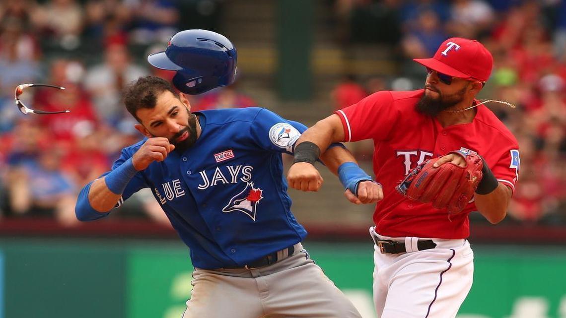 Toronto’s Jose Bautista, left, gets punched in the face by Rangers second baseman Rougned Odor during a game on May 15, 2016, at Globe Life Park.