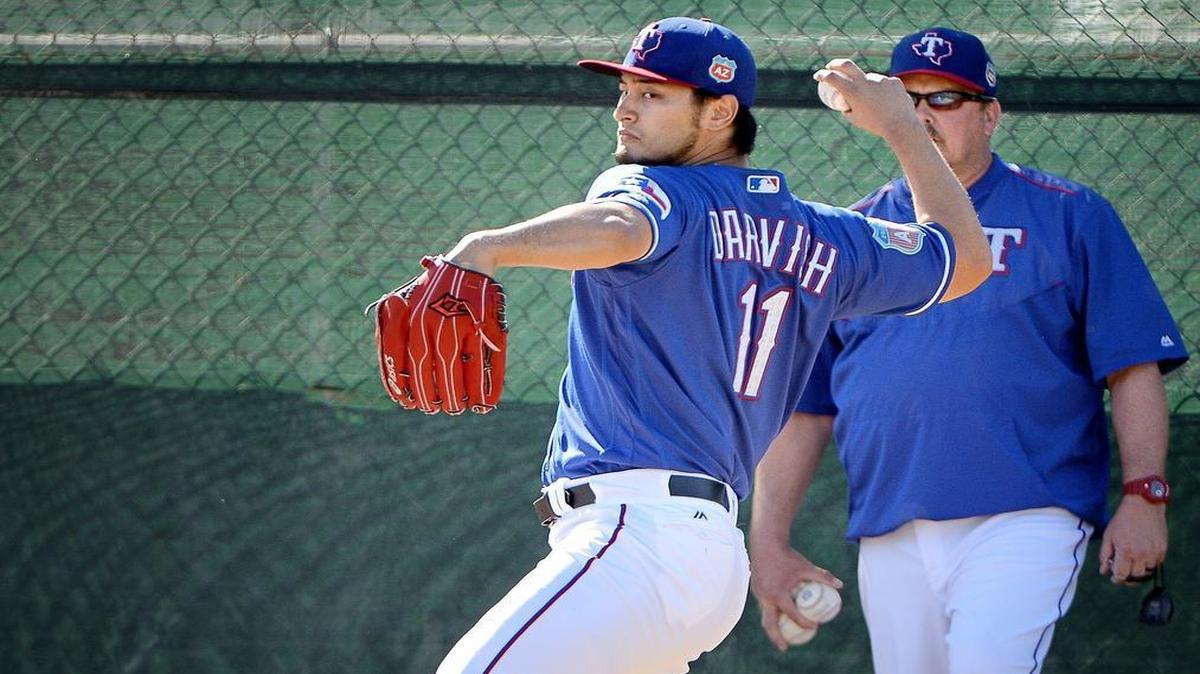 Rangers starting pitcher Yu Darvish, with bullpen coach Brad Holman behind him, threw his fifth bullpen session from the normal distance and off a regular mound Thursday morning in Surprise, Ariz. It was the one-year anniversary of his Tommy John surgery.