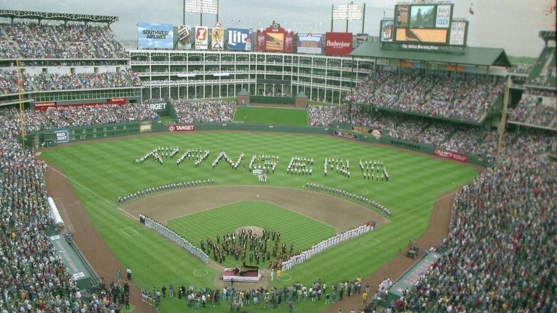 Texas Rangers fans stand as Van Cliburn and the Fort Worth Symphony play the national anthem for the first regular season game in the new Ballpark in Arlington in April 1994.