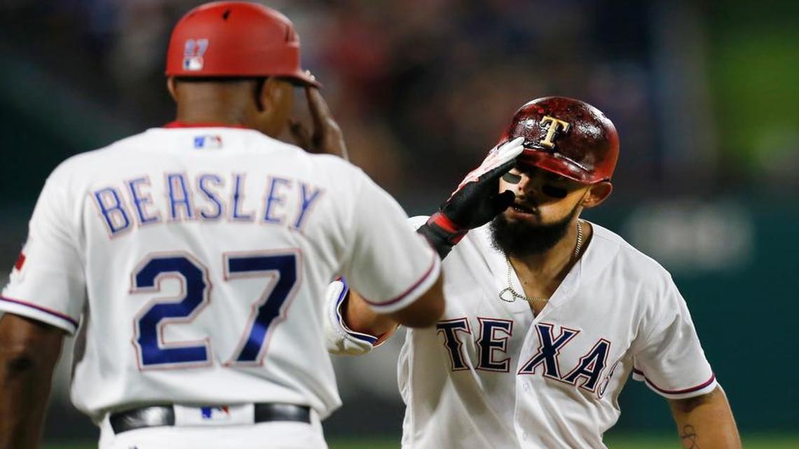 Texas Rangers second baseman Rougned Odor rounds third and salutes third base coach Tony Beasley (27) after hitting a solo home run against the Chicago White Sox in the fourth inning of a baseball game, Saturday Aug. 19, 2017, in Arlington, Texas.