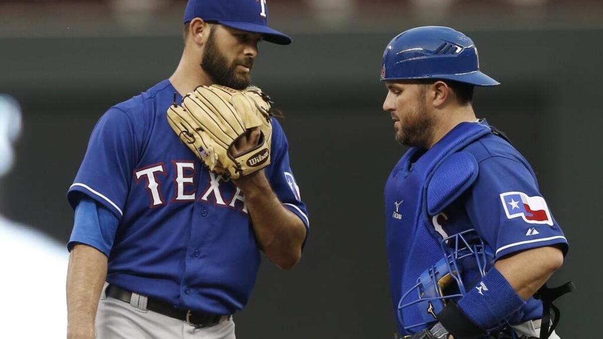 
Rangers starter Nick Martinez, talking with catcher Bobby Wilson, gave up three home runs and seven runs in 3 
2/3 innings. 
